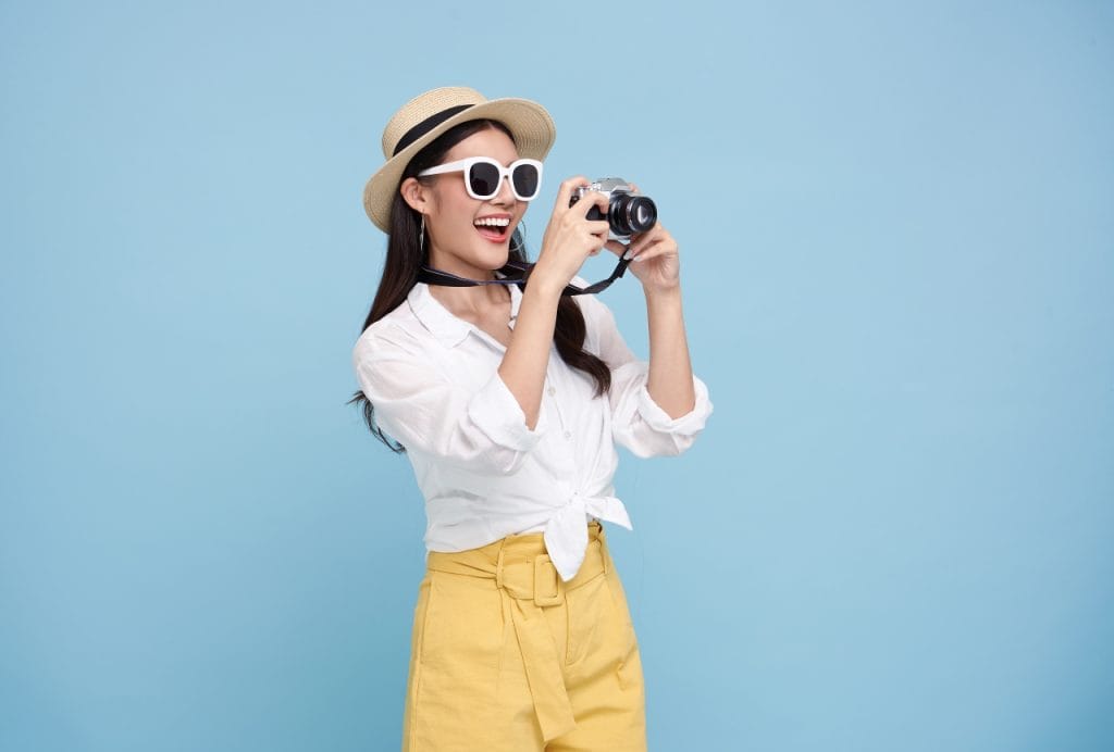 happy-smiling-young-asian-woman-tourist-summer-hat-standing-with-camera